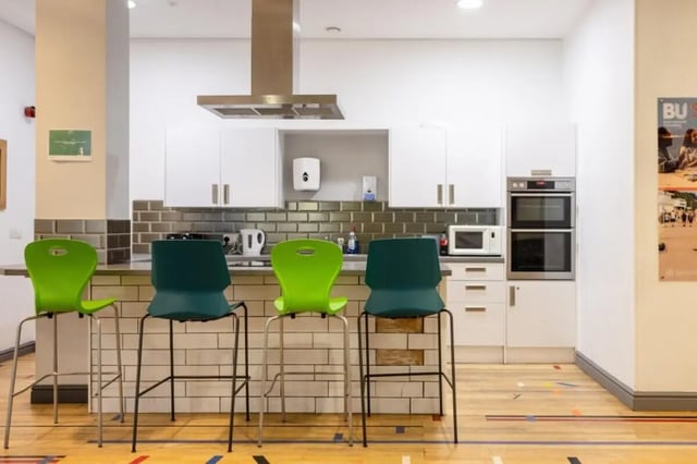 Bar stools and kitchen counter with ovens and microwave kitchen at Lyme Regis House in Bournemouth Student Accommodation