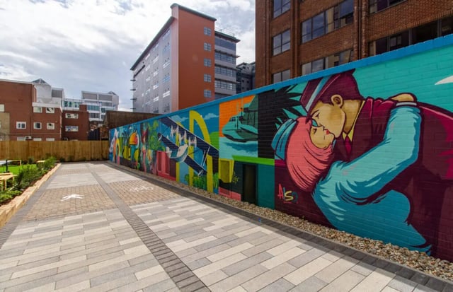 Colorful mural on brick wall with tiled courtyard exterior at Skyline in Bournemouth Student Accommodation