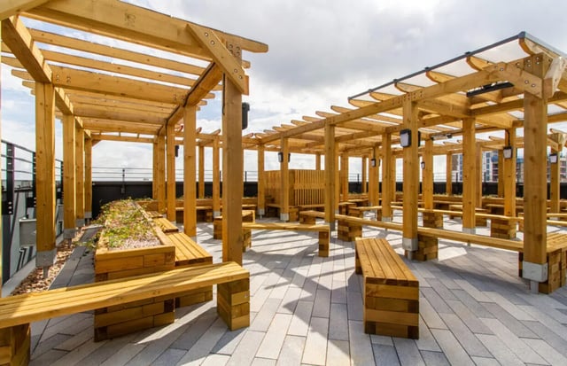 Wooden pergolas with benches and planter exterior at Skyline in Bournemouth Student Accommodation