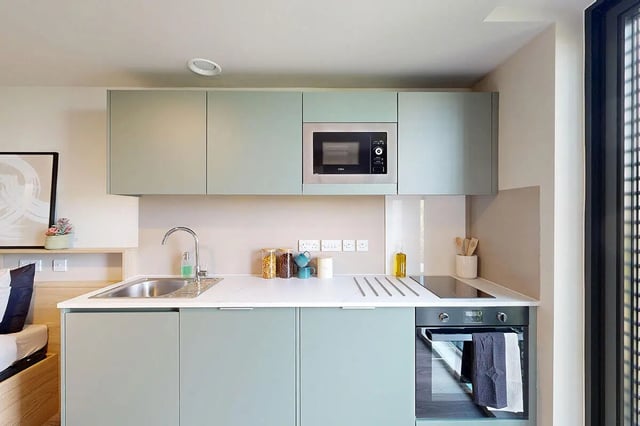 Mint green cabinets microwave sink and oven kitchen at Burnsall House in Coventry Student Accommodation