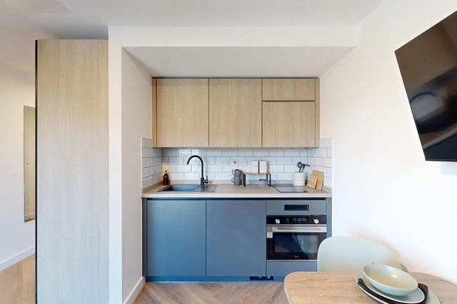 Modern kitchen with wood cabinets oven sink kitchen area at Bridgeside in Nottingham Student Accommodation
