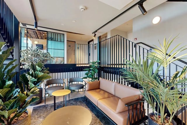 Sofa chairs tables plants interior living room at Bridgeside in Nottingham Student Accommodation