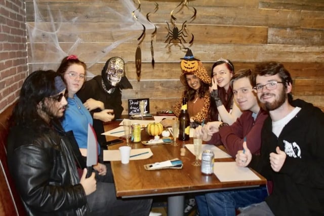 Group at Halloween party sitting at table living room at Cranborne House in Bournemouth Student Accommodation