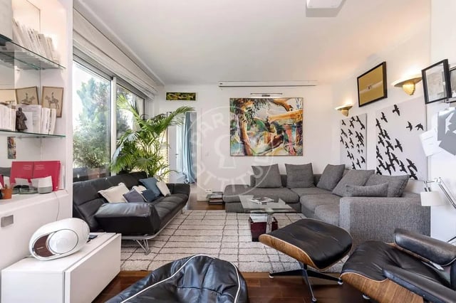 Modern living room with sectional sofa art and plants Living room at Apartment in Quai Louis Blériot, 75016 Paris, France in Paris Student Accommodation