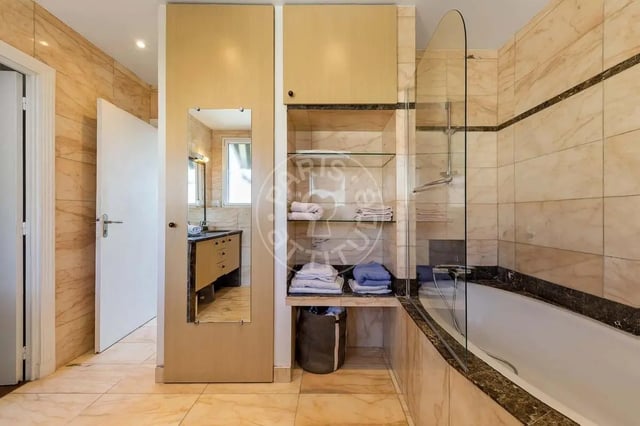 Marble tiled bathroom with bathtub and vanity Bathroom at Apartment in Quai Louis Blériot, 75016 Paris, France in Paris Student Accommodation
