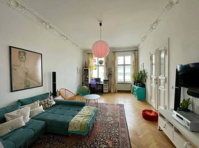 Sectional couch desk chairs plants rug living room at Apartment in Wallstraße, Berlin for 100 m² in Berlin Student Accommodation