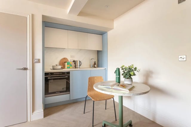 Compact kitchen with oven table and chair kitchen at Hamilton House in Brighton Student Accommodation