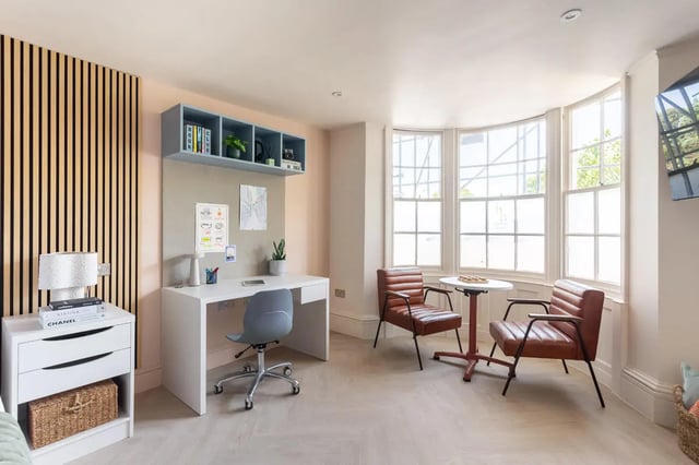 Desk chairs shelf and two armchairs living room at Hamilton House in Brighton Student Accommodation