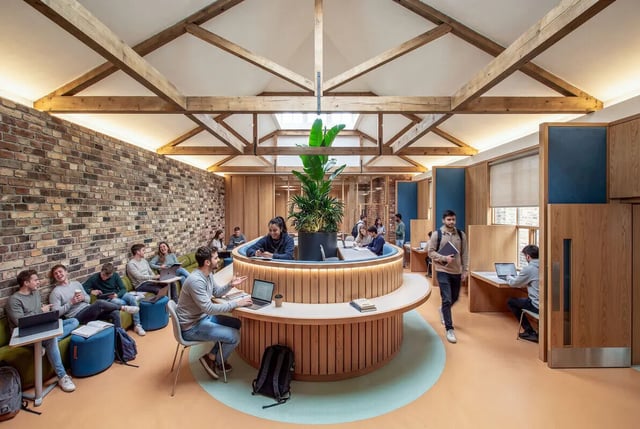 Students studying at circular desks with plants study area at Hamilton House in Brighton Student Accommodation
