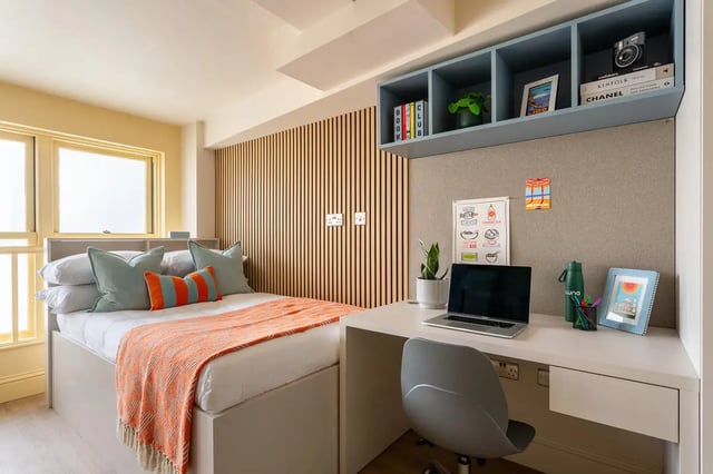 Bed with orange throw laptop study desk bedroom at Hamilton House in Brighton Student Accommodation