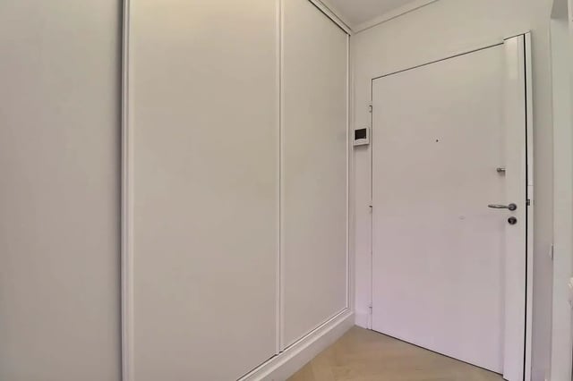 Hallway with white sliding doors and a white door Hallway at Apartment in Pass. du Guesclin, 75015 Paris, France in Paris Student Accommodation