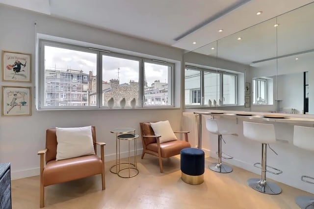 Two chairs bar stools and a counter living room at Apartment in Pass. du Guesclin, 75015 Paris, France in Paris Student Accommodation