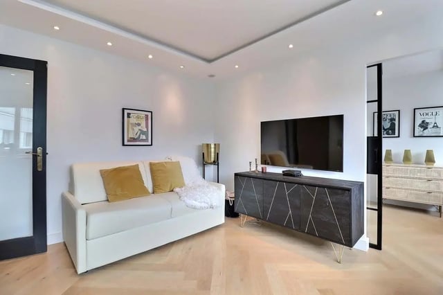 White sofa with yellow pillows and throw living room at Apartment in Pass. du Guesclin, 75015 Paris, France in Paris Student Accommodation