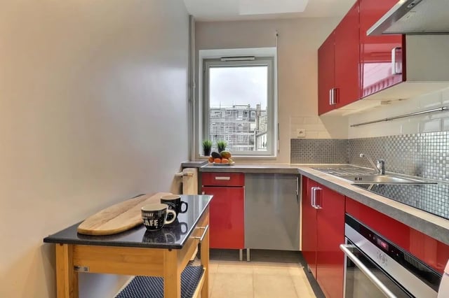 Red cabinets sink oven and mugs kitchen at Apartment in Pass. du Guesclin, 75015 Paris, France in Paris Student Accommodation