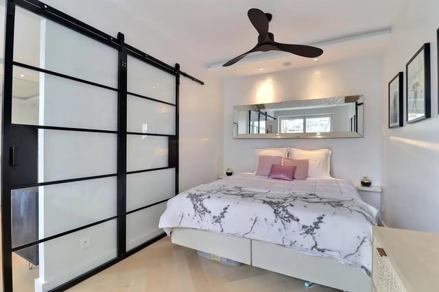 Sliding glass doors mirror and bed with pink pillows bedroom at Apartment in Pass. du Guesclin, 75015 Paris, France in Paris Student Accommodation