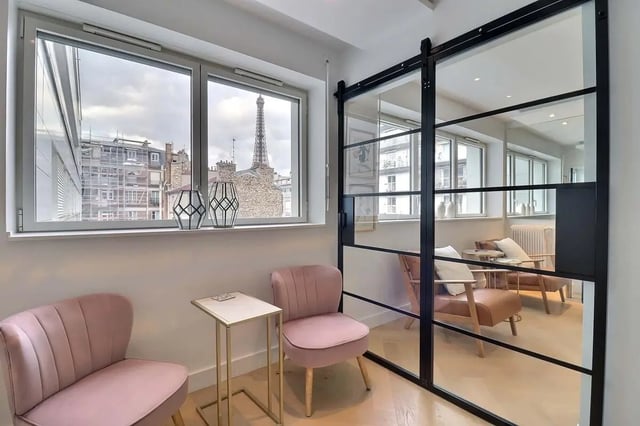 Pink chairs small table glass door living room at Apartment in Pass. du Guesclin, 75015 Paris, France in Paris Student Accommodation