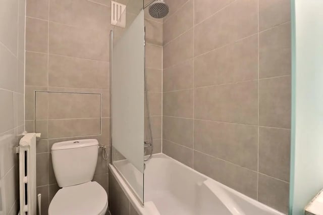 Toilet and bathtub with frosted glass screen bathroom at Apartment in Pass. du Guesclin, 75015 Paris, France in Paris Student Accommodation
