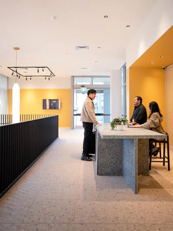People at reception desk with modern decor Lobby at The Switch Lachlan Macquarie Park in Sydney Student Accommodation