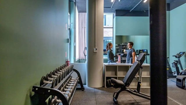 Dumbbells bench exercise machines gym area at Assemble Swiftwalk in Melbourne Student Accommodation