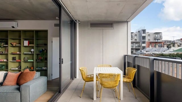 Balcony with table chairs and city view balcony at Assemble Swiftwalk in Melbourne Student Accommodation