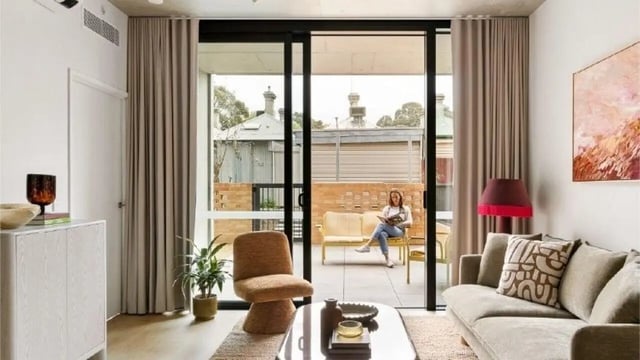 Modern living room with sofa armchair and balcony living room at Assemble Swiftwalk in Melbourne Student Accommodation