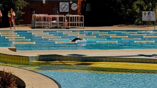 Swimming pool with lanes and swimmer outdoor pool at Assemble Swiftwalk in Melbourne Student Accommodation