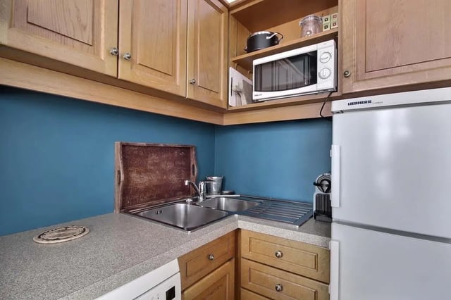Sink microwave refrigerator wood cabinets kitchen at Apartment in Rue Bergère, 75009 Paris, France in Paris Student Accommodation