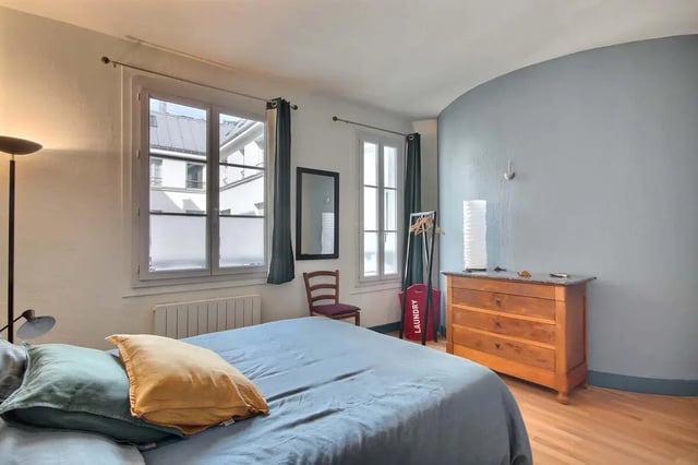 Bed with pillows dresser laundry bag bedroom at Apartment in Rue Bergère, 75009 Paris, France in Paris Student Accommodation