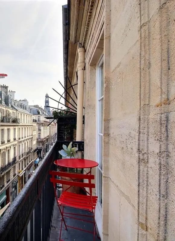 Red table and chair balcony with city view exterior at Apartment in Rue Bergère, 75009 Paris, France in Paris Student Accommodation
