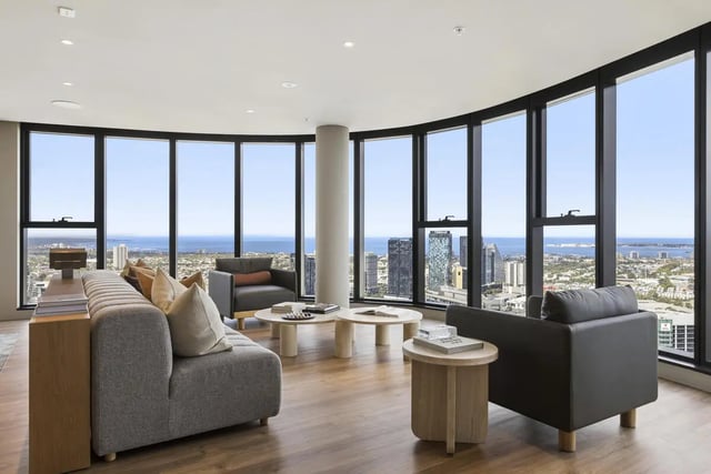 Sofa chairs coffee tables with city view living room at West Tower, Melbourne Quarter in Melbourne Student Accommodation