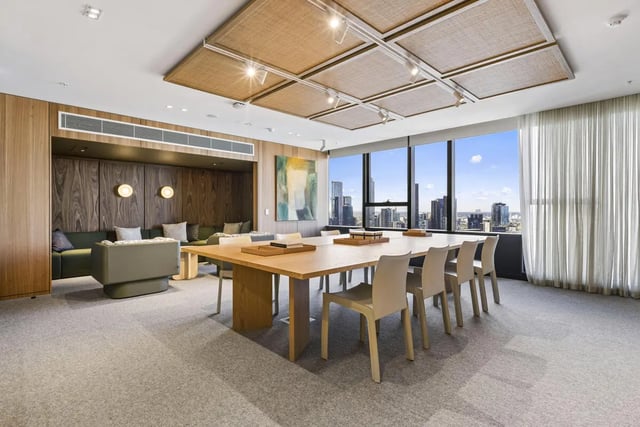 Table with chairs and lounge seating living area at West Tower, Melbourne Quarter in Melbourne Student Accommodation