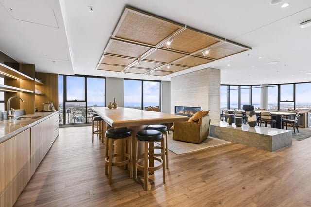 Kitchen island with stools fireplace communal dining Living room at West Tower, Melbourne Quarter in Melbourne Student Accommodation