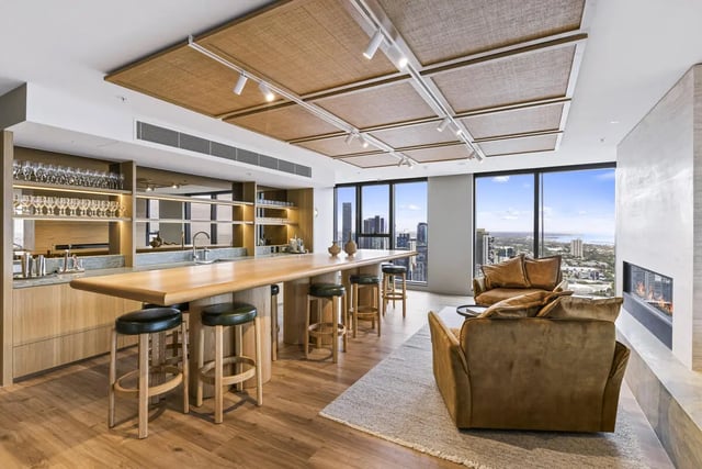 Bar stools at long kitchen island with city view Living room at West Tower, Melbourne Quarter in Melbourne Student Accommodation