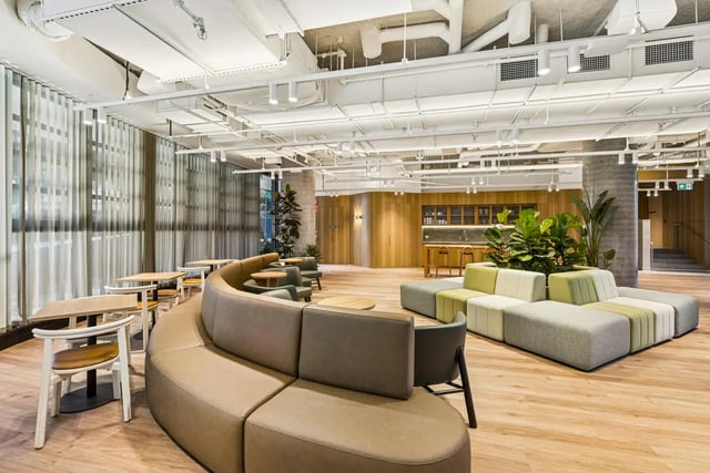 Modular sofas tables chairs plants kitchen common area at West Tower, Melbourne Quarter in Melbourne Student Accommodation