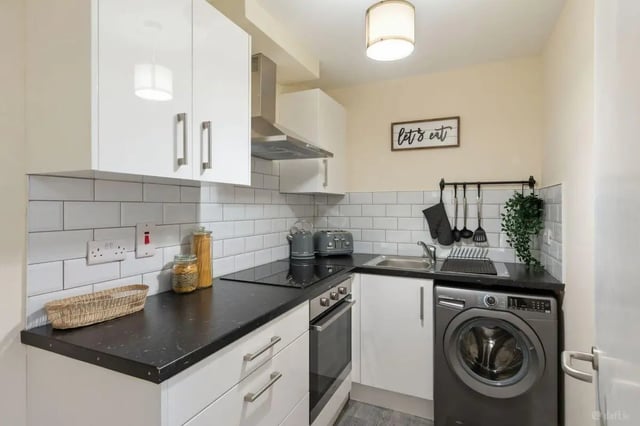 Compact kitchen with white cabinets oven and washing machine kitchen at 16 Emmet Lodge, Emmet Court, Dublin 8 D08 EY83 in Dublin Student Accommodation