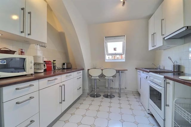 White cabinets microwave oven stove bar stools kitchen at Apartment in Rue César Franck, 75015 Paris, France in Paris Student Accommodation