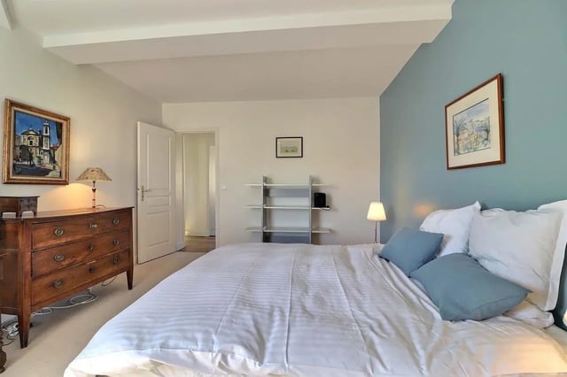 Chest dresser painting lamp bed with pillows bedroom at Apartment in Rue César Franck, 75015 Paris, France in Paris Student Accommodation