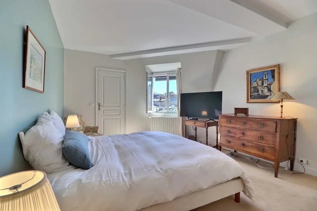 Bed with white duvet dresser television bedroom at Apartment in Rue César Franck, 75015 Paris, France in Paris Student Accommodation