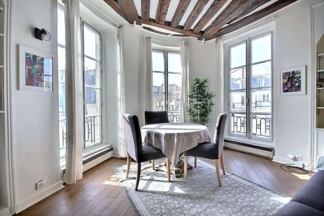 Round table three chairs artwork plant dining area at Apartment in Rue Dauphine, 75006 Paris, France in Paris Student Accommodation