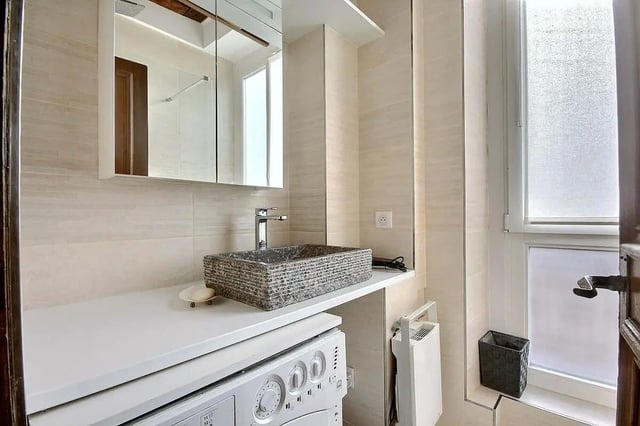 Washing machine stone sink mirror cabinet bathroom at Apartment in Rue Dauphine, 75006 Paris, France in Paris Student Accommodation