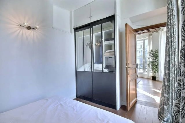 Bed with wardrobe and open door bedroom at Apartment in Rue Dauphine, 75006 Paris, France in Paris Student Accommodation