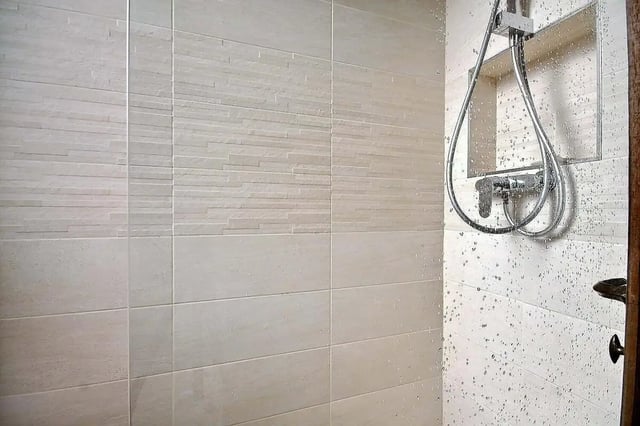 Tiled shower with chrome fixtures and water droplets Bathroom at Apartment in Rue Dauphine, 75006 Paris, France in Paris Student Accommodation