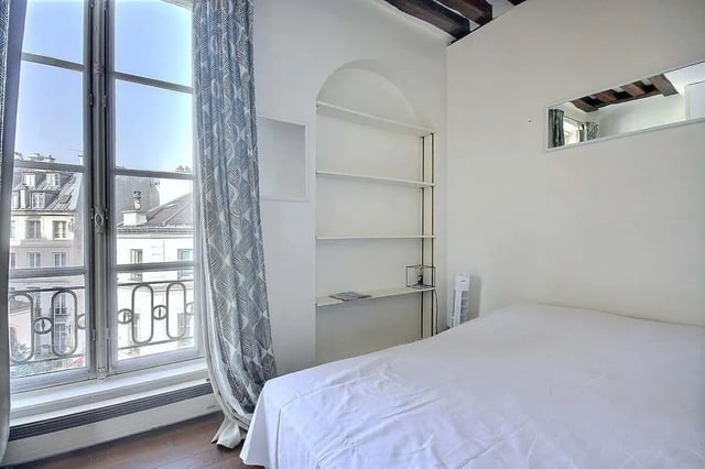 Bed white curtains shelving window exterior bedroom at Apartment in Rue Dauphine, 75006 Paris, France in Paris Student Accommodation