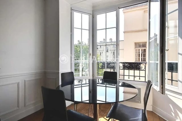 Round dining table with chairs and windows dining area at Apartment in Cité Voltaire, 75011 Paris, France in Paris Student Accommodation