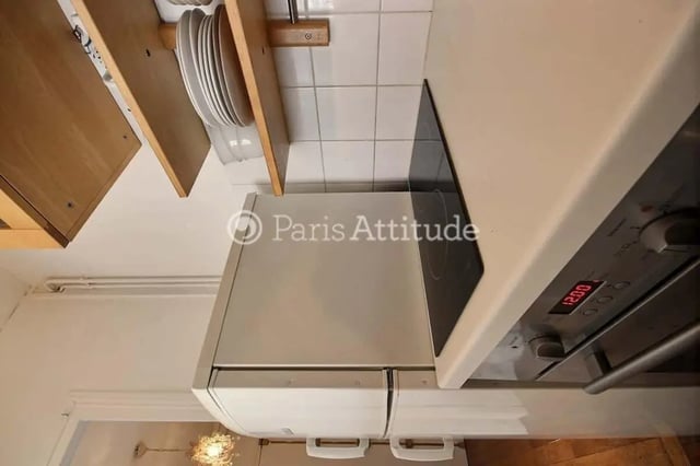 Stack of plates on shelf oven and stovetop kitchen at Apartment in Cité Voltaire, 75011 Paris, France in Paris Student Accommodation