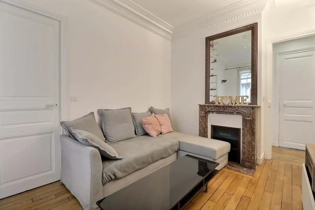 Grey sectional sofa fireplace mirror living room at Apartment in Rue Etienne Jodelle, 75018 Paris, France in Paris Student Accommodation