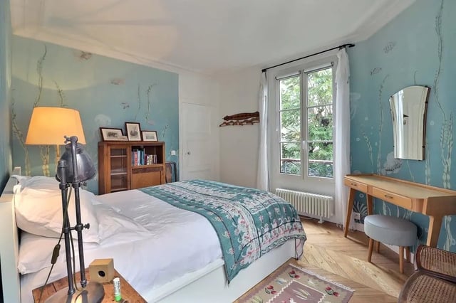 Bed with patterned throw bookshelf lamp vanity mirror bedroom at Apartment in Rue Clauzel, 75009 Paris, France in Paris Student Accommodation