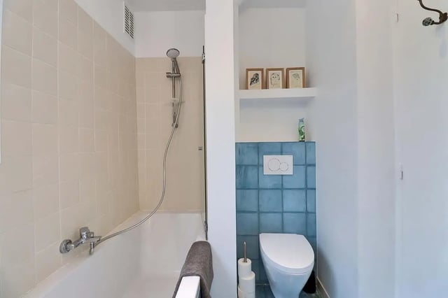 Bathtub shower toilet and artwork Bathroom at Apartment in Rue Clauzel, 75009 Paris, France in Paris Student Accommodation