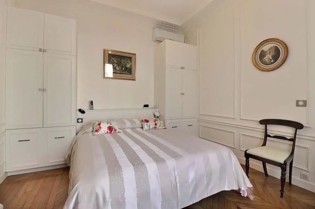White bed with patterned pillows and wardrobes bedroom at Apartment in Rue Villaret de Joyeuse, 75017 Paris, France in Paris Student Accommodation