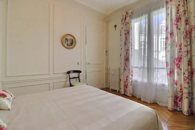 Bed chair framed art floral curtains bedroom at Apartment in Rue Villaret de Joyeuse, 75017 Paris, France in Paris Student Accommodation